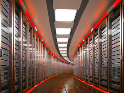 A long corridor that curves out of view to the right with both walls lined with servers where the top and the bottom of the walls are lined with red lights