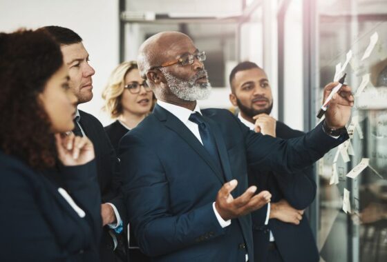 A group of business people looking at a board.