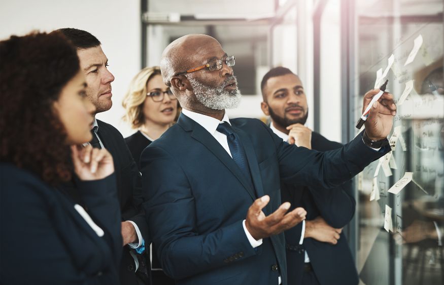 A group of business people looking at a board.