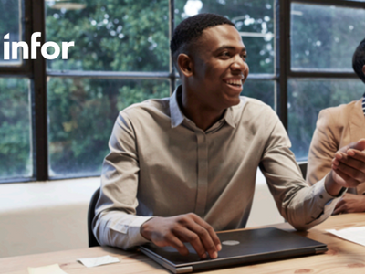 A group of people sitting at a desk with a laptop in front of them.