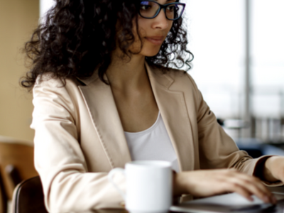 A woman sitting at a table with a laptop.