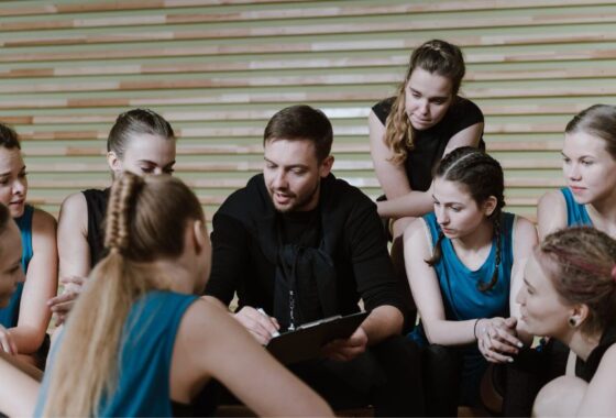 A group of people sitting around a court.