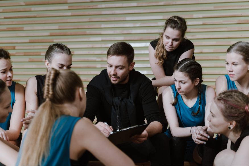 A group of people sitting around a court.