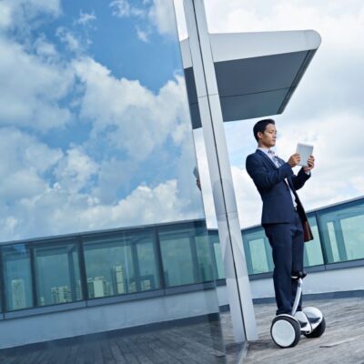 A man in a suit is using a device on a rooftop.