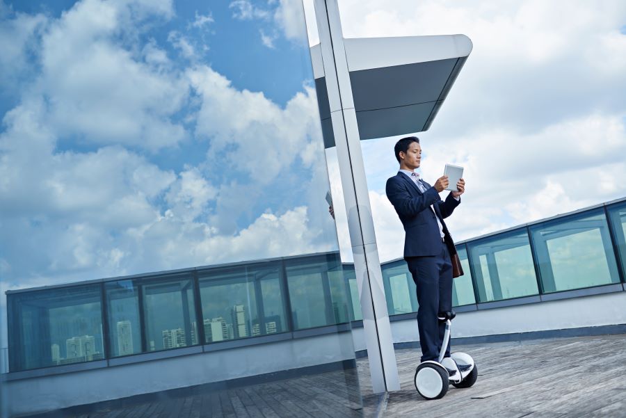 A man in a suit is using a device on a rooftop.
