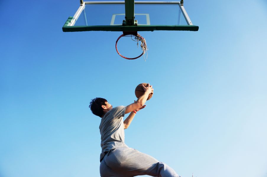 A man dunks a basketball in the air.