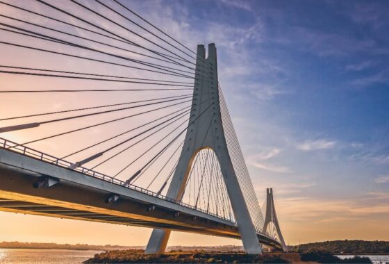 A bridge over a body of water at sunset.