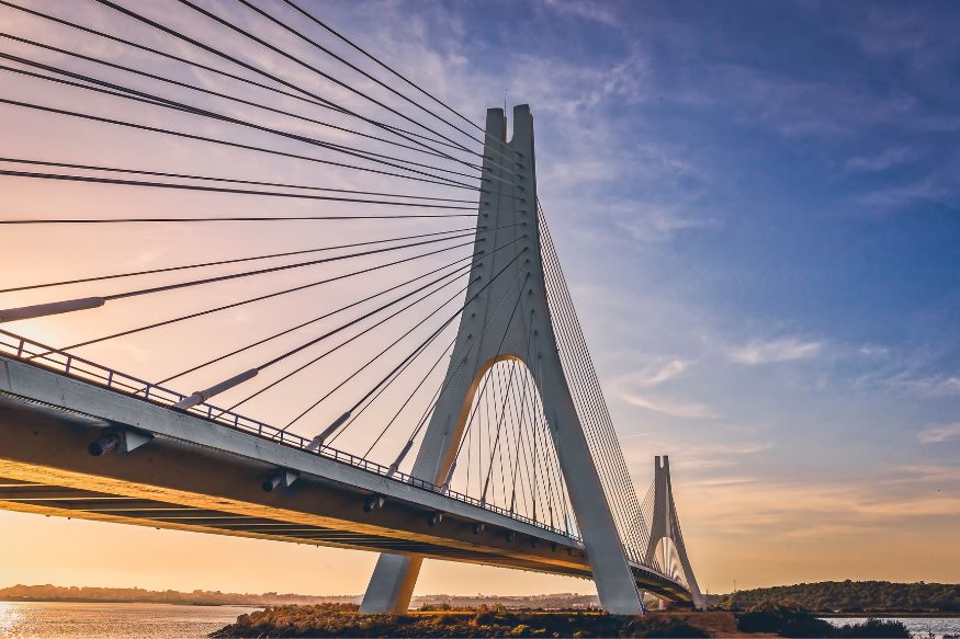 A bridge over a body of water at sunset.