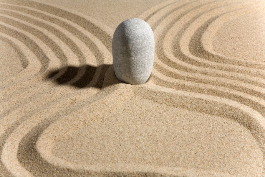 A stone sits in the sand in a zen garden.
