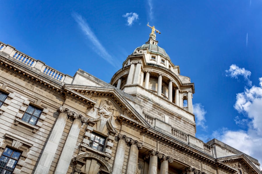 Low angle shot of a courthouse against a bright blue sky.