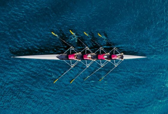 A group of rowers in a boat on the ocean.
