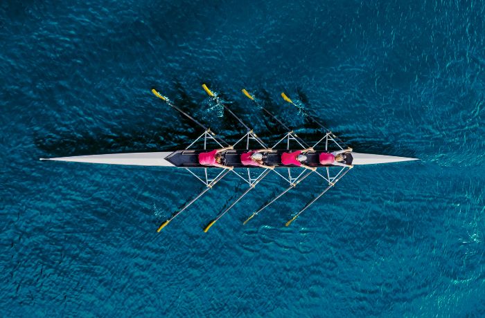 A group of rowers in a boat on the ocean.