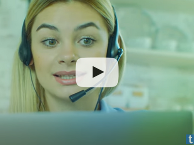 A woman wearing a headset and looking at a screen.