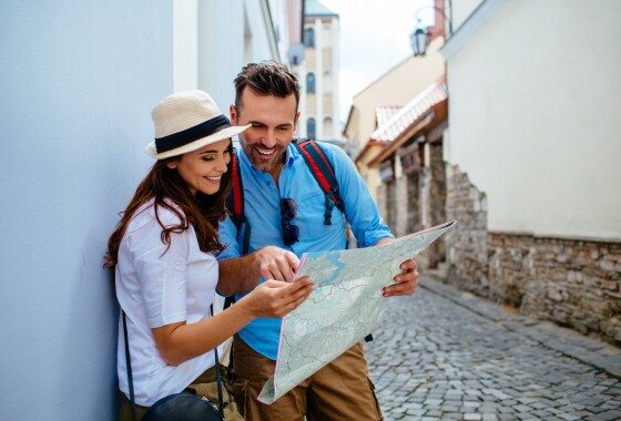 A couple looking at a map on a cobblestone street.