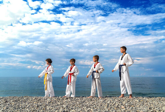 A group of karate kids standing on a beach.