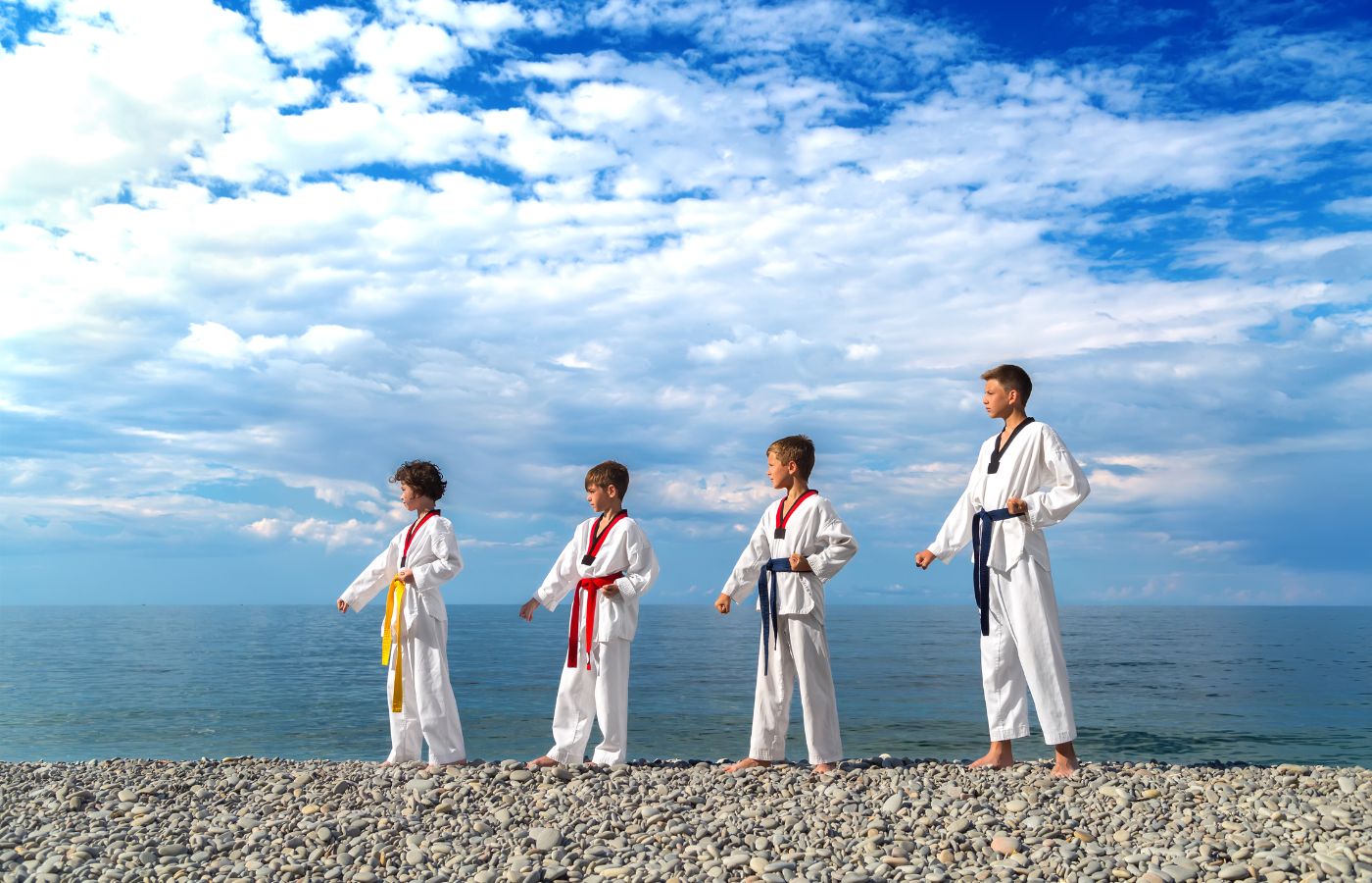 A group of karate kids standing on a beach.