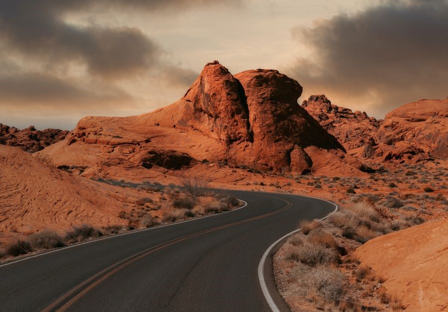 A road in the desert with mountains in the background.