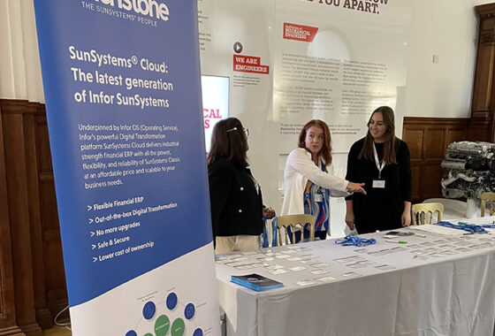 Two women shaking hands in front of a table with a touchstone banner.