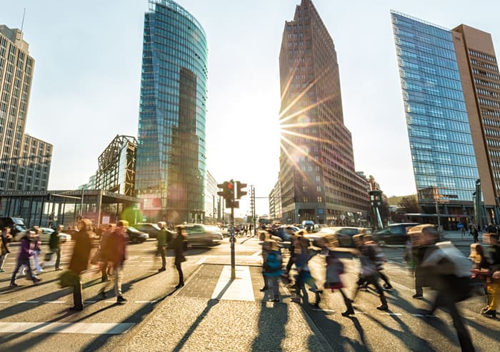 A group of people crossing a street in a city.