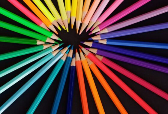 Colorful pencils arranged in a circle on a black background.