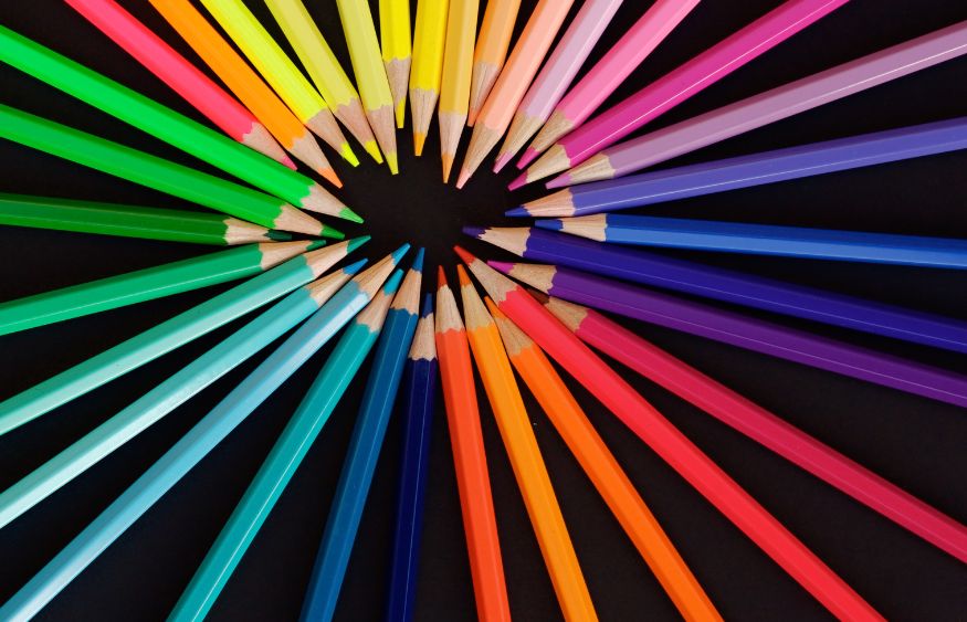 Colorful pencils arranged in a circle on a black background.