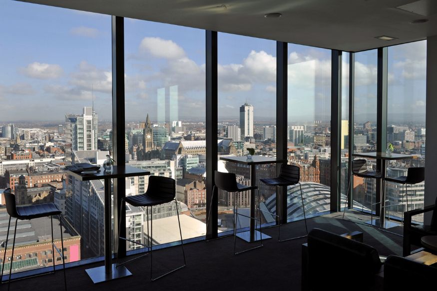 Skyline view from roof top bar with tall buildings and cloudy sky