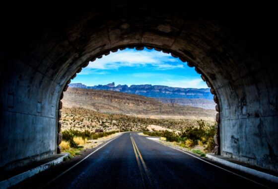 A road through a tunnel with mountains in the background.