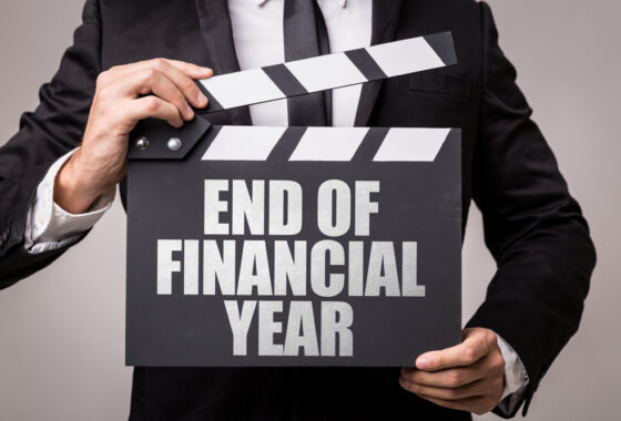 A businessman holding a sign that says end of financial year.